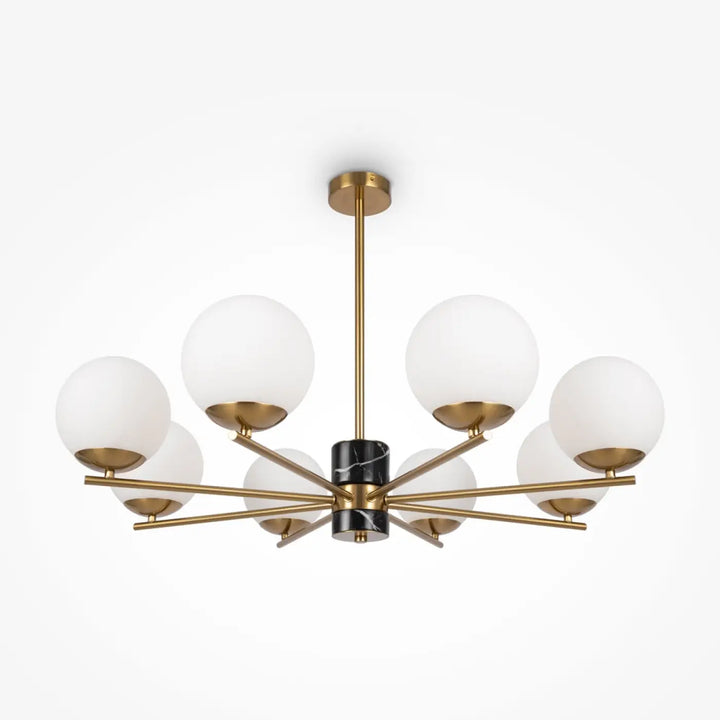 Suspension luminaire marble avec colonne noire en marbre et structure dorée au-dessus d’une pièce avec six globes en verre dépoli