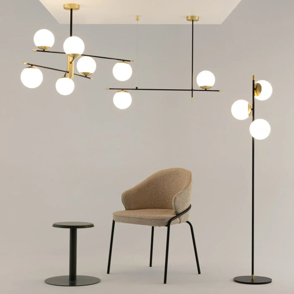 Suspension luminaire nostalgia linéaire en acier noir avec globe sphérique verre opalin au-dessus d’une table