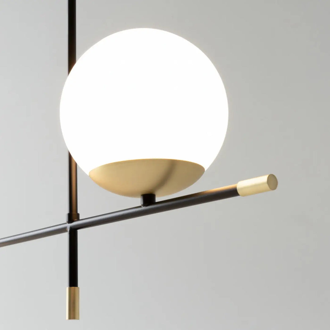 Suspension luminaire nostalgia linéaire avec verre opalin et acier noir au-dessus d’une table moderne