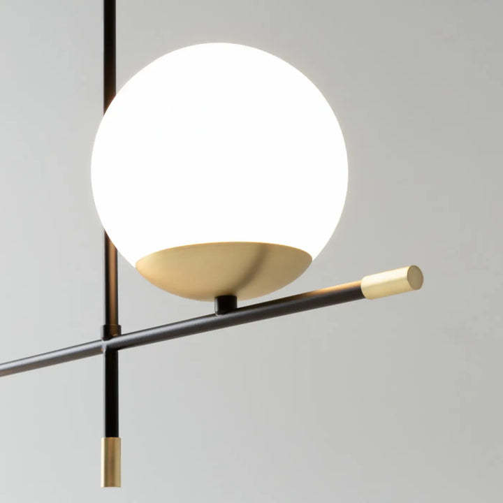 Suspension luminaire nostalgia linéaire avec verre opalin et acier noir au-dessus d’une table moderne