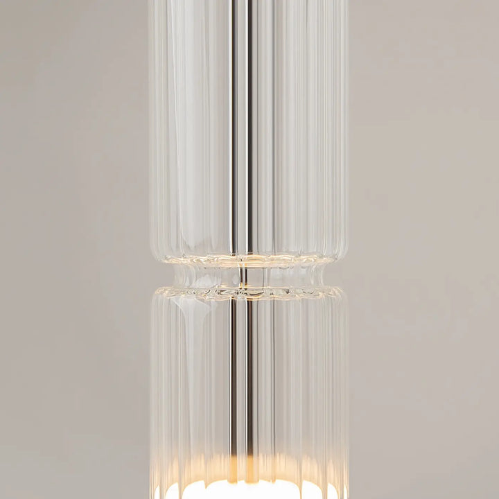 Suspension ordo led en verre clair avec rainures verticales et tige métallique centrale pour un éclairage élégant