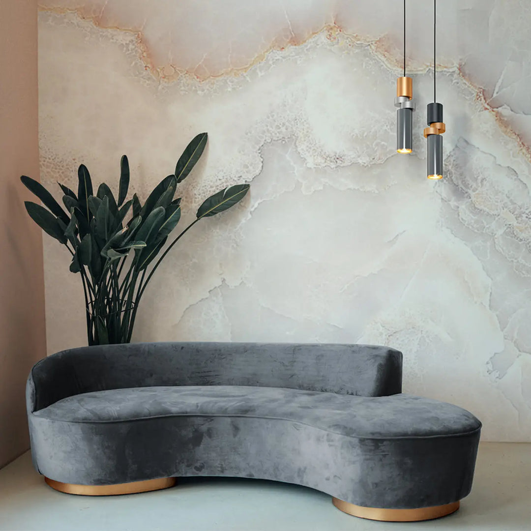 Suspension palette tube asymétrique en verre gris avec base disque cuivré et canapé en velours gris incurvé