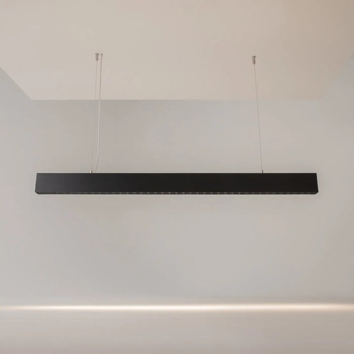 Suspension luminaire points lumineux barre noire rectangulaire led moderne suspendue au-dessus d’un îlot avec deux cordons fins