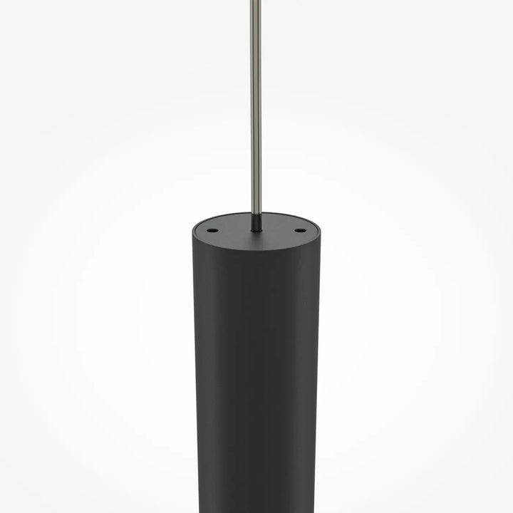 Suspension pro tube lumineux en cylindre noir mat avec tige métallique fine au-dessus d’un espace moderne