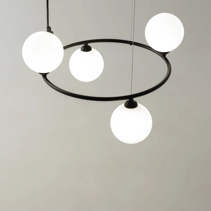 Suspension ring noire en métal moderne avec quatre globes en verre dépoli blanc pour une touche art déco