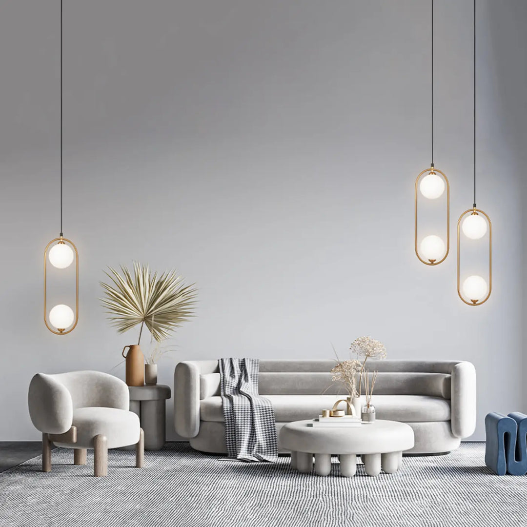 Suspension ring modern minimaliste avec cadres ovales dorés et ampoules en verre dépoli au-dessus d’un îlot art déco