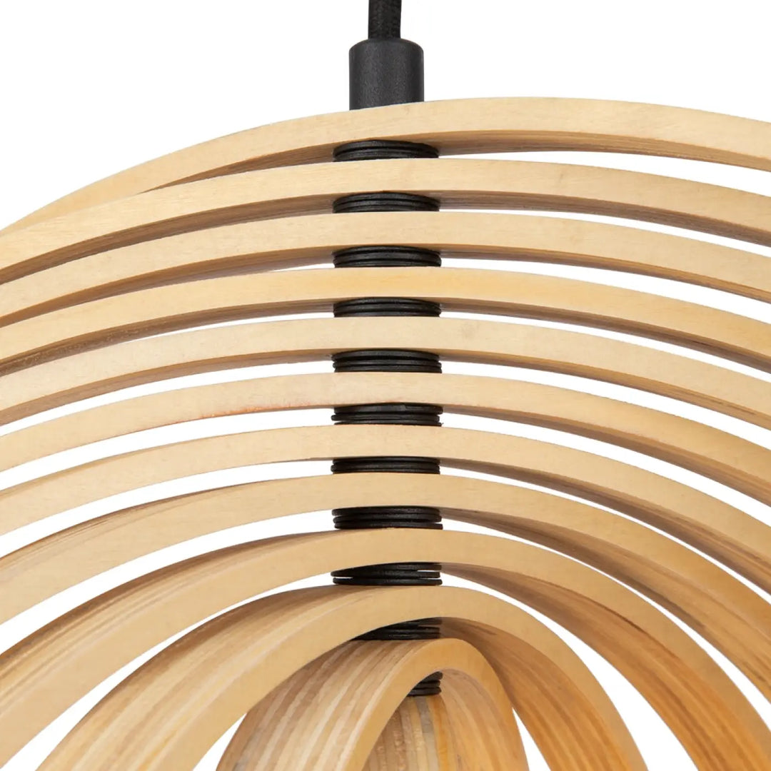 Suspension luminaire roots avec anneaux en bois naturel courbés et finition noire au-dessus d’une table moderne