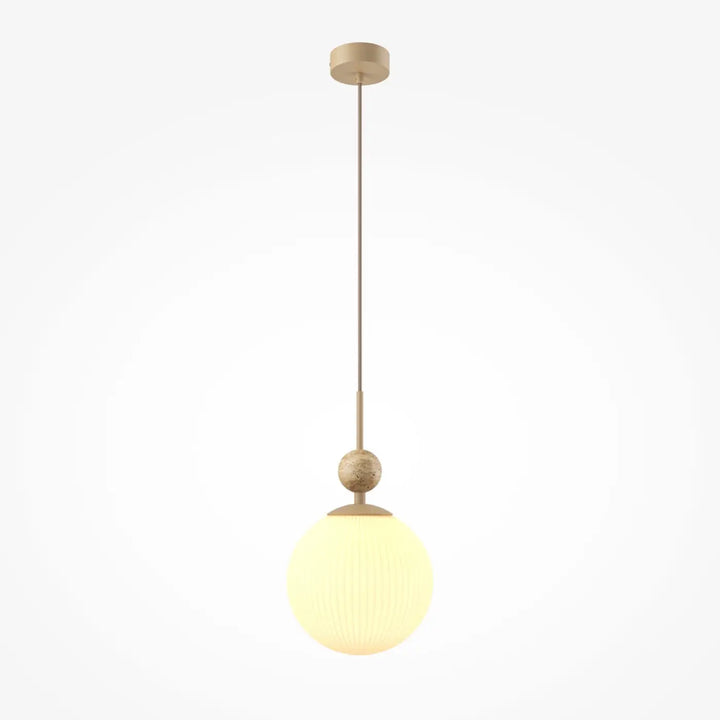 Suspension tavo moderne avec globe en verre diffusant une lumière chaude et sphère en laiton texturé pour une touche minérale au-dessus d’une table