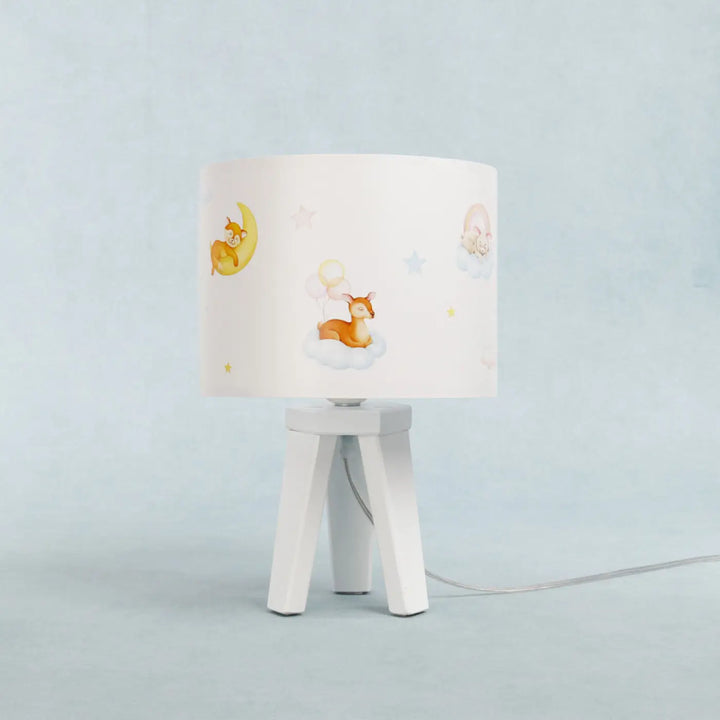 Lampe de table sweet dreams blanc avec abat-jour cylindrique illustré de cerfs lunes et étoiles sur pied trépied blanc